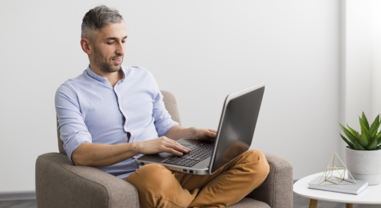 Homem sentado na cadeira e escrevendo no seu laptop representando um proprietário de imóvel de temporada lendo dicas para anfitriões 
Foto: freepik